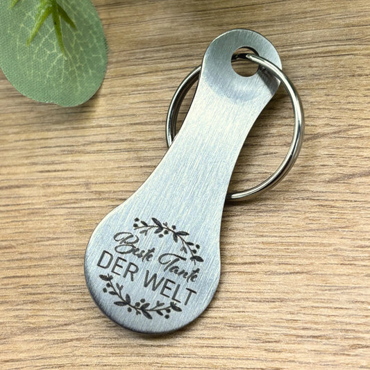 „Schlüsselanhänger aus Edelstahl mit Gravur 'Beste Tante der Welt' – hochwertiges Geschenk für Frauen, stilvoll auf Holzoberfläche präsentiert“