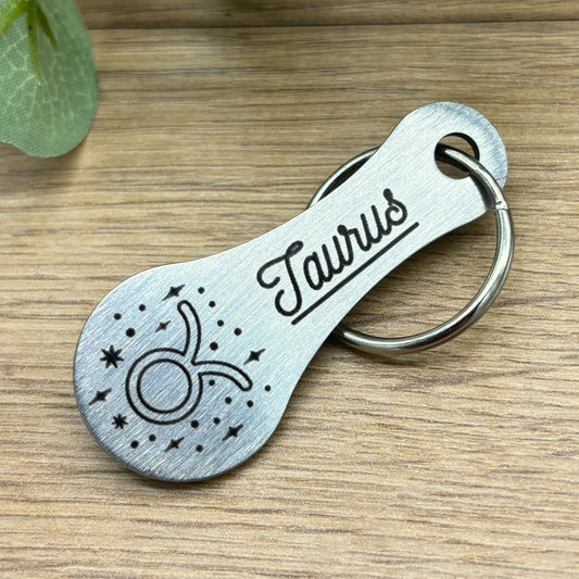 Schlüsselanhänger mit Sternzeichen Taurus Gravur aus Edelstahl – hochwertig verarbeitetes Motiv auf Holzoberfläche